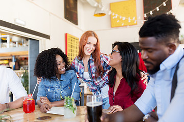 Image showing happy friends with drinks at bar or restaurant