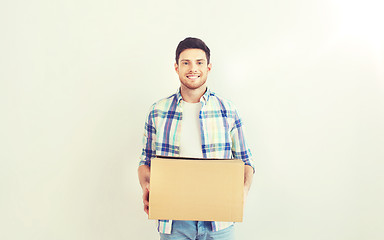 Image showing smiling young man with cardboard box at home