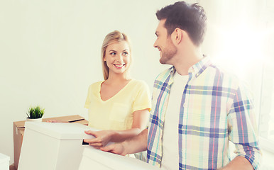 Image showing smiling couple with big boxes moving to new home