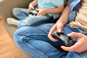 Image showing close up of father and son playing video game