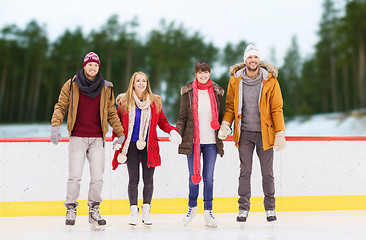 Image showing friends holding hands on outdoor skating rink