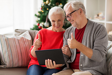 Image showing happy senior couple with tablet pc at christmas