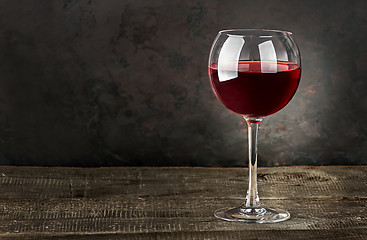 Image showing Glass of red wine on a wooden table