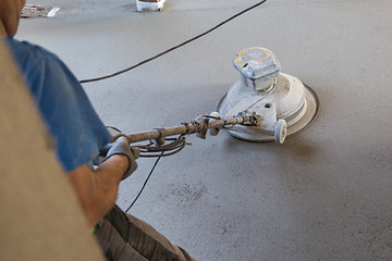 Image showing Laborer polishing sand and cement screed floor.