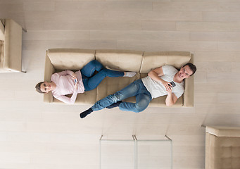 Image showing couple on sofa using mobile phones top view