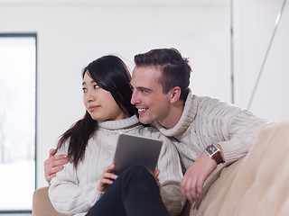 Image showing multiethnic couple at home using tablet computers