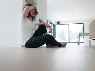 Image showing young man using a tablet at home