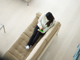 Image showing top view of asian woman using Digital Tablet on sofa