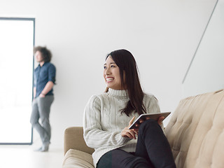 Image showing multiethnic couple at home using tablet computers