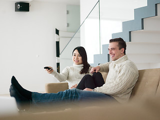 Image showing multiethnic couple on the sofa watching television