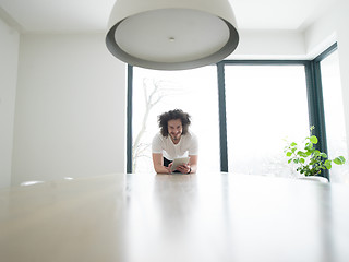 Image showing young man using a tablet at home