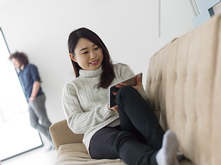 Image showing multiethnic couple at home using tablet computers