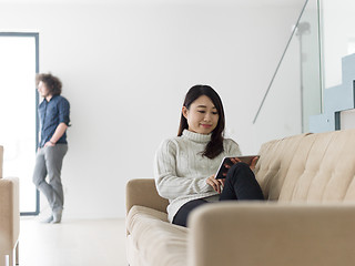 Image showing multiethnic couple at home using tablet computers
