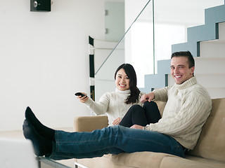 Image showing multiethnic couple on the sofa watching television