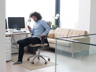 Image showing man using a mobile phone  at home