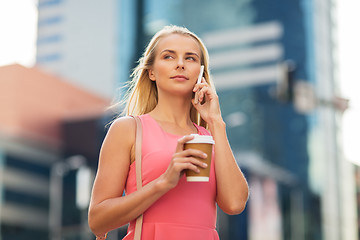 Image showing woman with coffee calling on smartphone in city