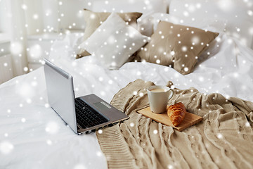 Image showing laptop, coffee and croissant on bed at cozy home