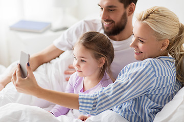 Image showing happy family taking selfie by smartphone at home