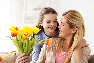 Image showing happy girl giving flowers to mother at home