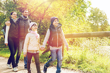 Image showing happy family with backpacks hiking in woods