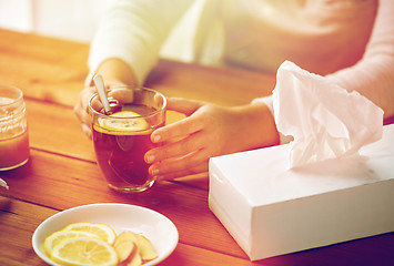 Image showing close up of ill woman drinking tea with lemon