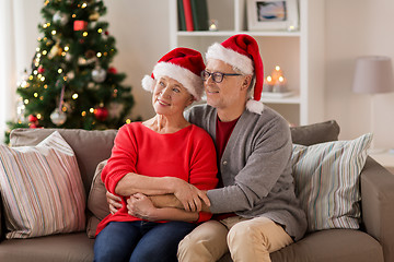 Image showing happy senior couple in santa hats at christmas