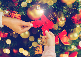 Image showing close up of family decorating christmas tree