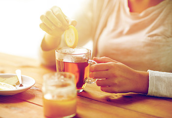 Image showing close up of ill woman drinking tea with lemon