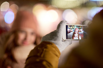 Image showing hand with woman christmas picture on smartphone  