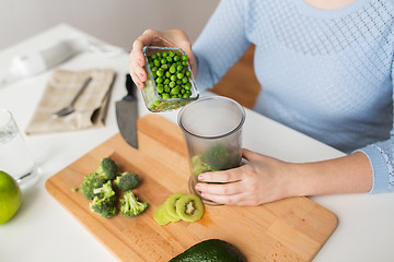 Image showing woman hand adding pea to measuring cup