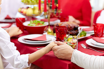 Image showing family having holiday dinner and praying at home