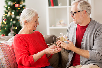 Image showing happy smiling senior couple with christmas gift