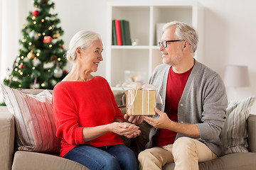 Image showing happy smiling senior couple with christmas gift