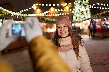 Image showing happy woman posing for smartphone at christmas