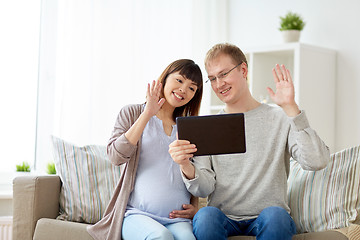 Image showing husband and pregnant wife with tablet pc at home