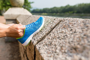 Image showing Woman fixing the shoelace