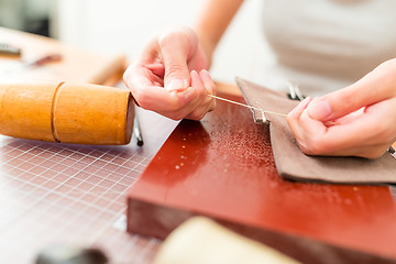 Image showing Leather handbag craftsman at work in a workshop