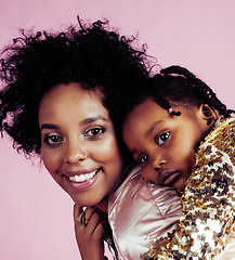 Image showing young pretty african-american mother with little cute daughter hugging, happy smiling on pink background, lifestyle modern people concept