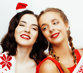 Image showing young pretty happy smiling blond and brunette woman girlfriends on christmas in santas red hat and holiday decorated plaid, lifestyle people concept 