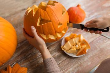 Image showing close up of woman carving halloween pumpkin