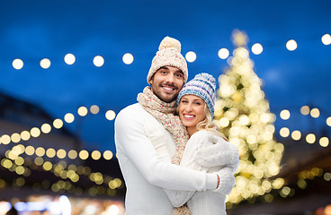 Image showing happy couple hugging over christmas lights