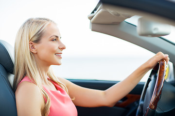 Image showing happy young woman driving convertible car