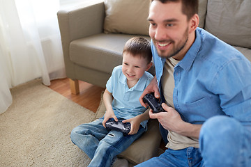 Image showing father and son playing video game at home