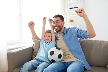 Image showing father and son watching soccer on tv at home