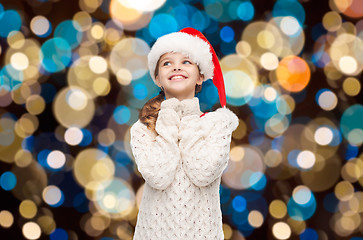 Image showing dreaming girl in santa helper hat over lights