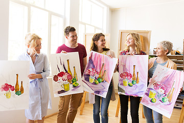 Image showing group of artists with pictures at art school