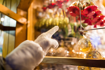 Image showing hand pointing at christmas toys behind shop window