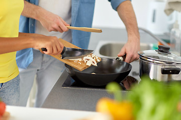 Image showing multiethnic couple cooking food at home kitchen