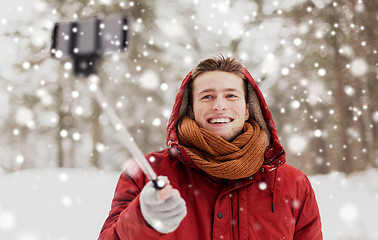 Image showing happy man taking selfie by smartphone in winter