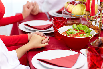 Image showing family having holiday dinner and praying at home